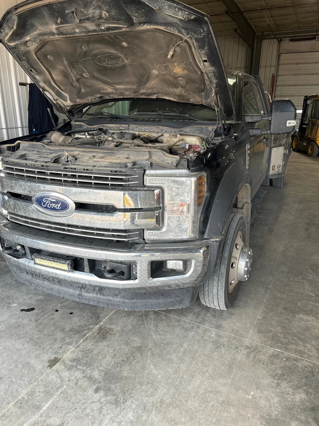 Pickup truck in a service shop with its hood open