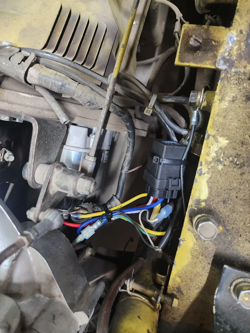 Starter relay and wiring connections in an equipment engine compartment