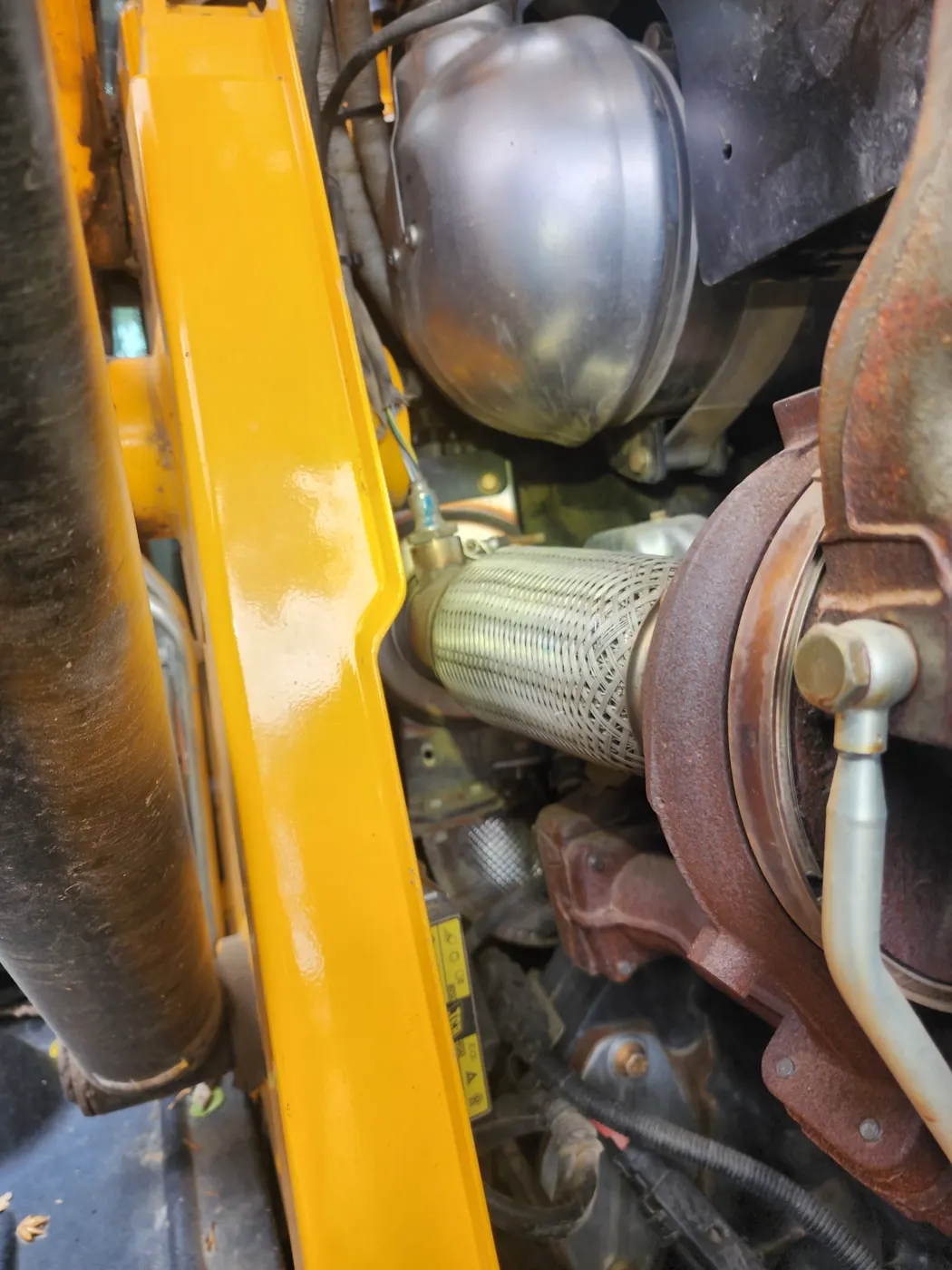 Backhoe loader engine compartment with turbocharger and exhaust components