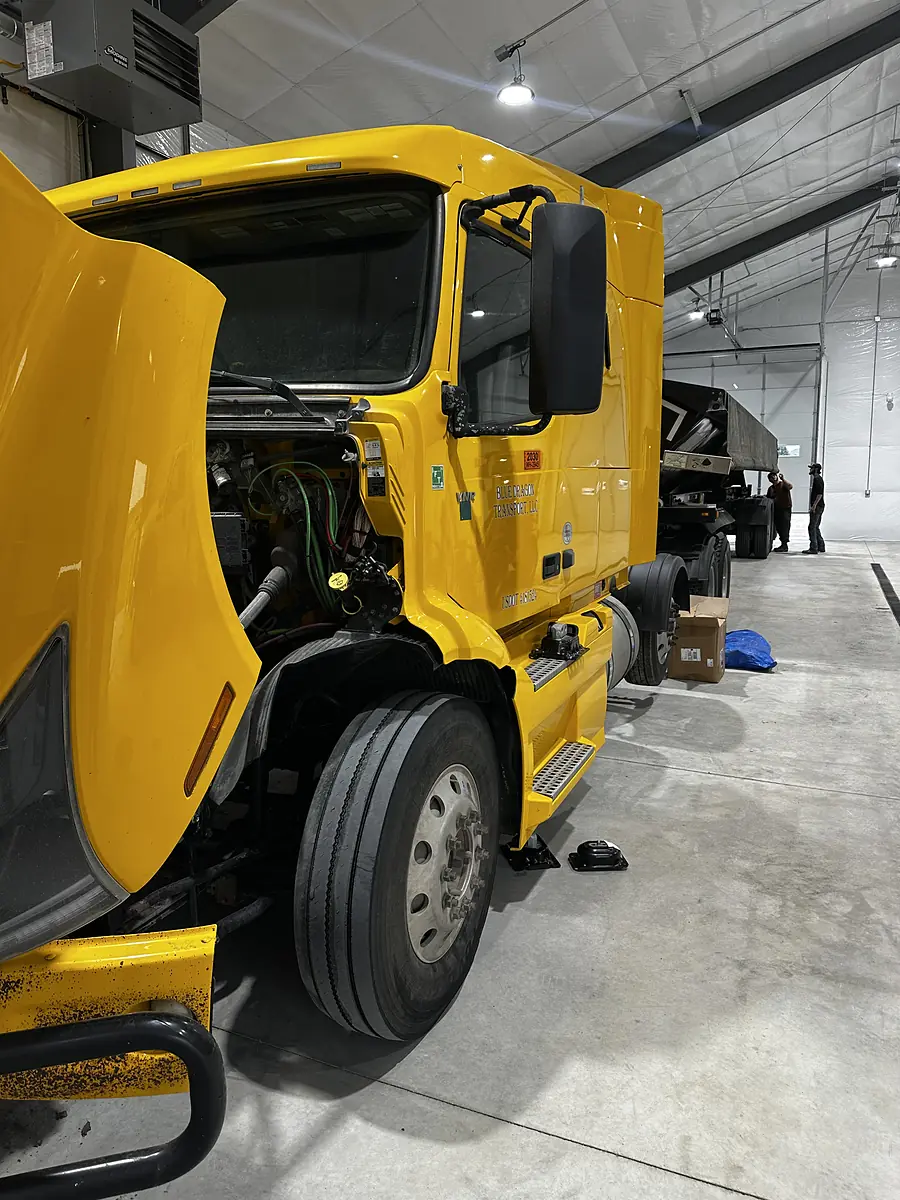 Commercial truck in a Mondak Equipment repair shop with hood open